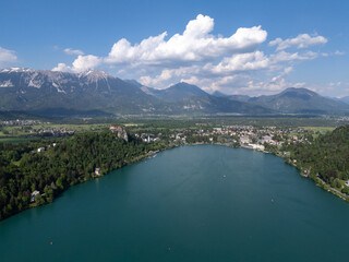 Aerial view of Bled Castle overlooking Lake Bled, Slovenia. Medieval fortress on a cliff captured by drone, surrounded by alpine landscape and clear blue water. Famous European travel destination and 