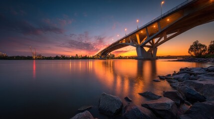 Dramatic sunset over a modern bridge with reflections on tranquil water
