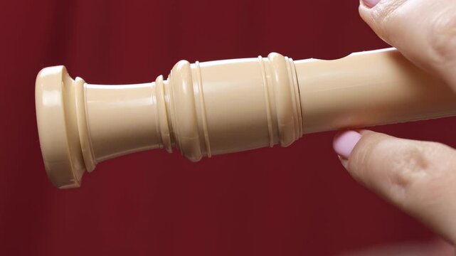Woman holding in her hands and playing block flute (recorder) musical instrument