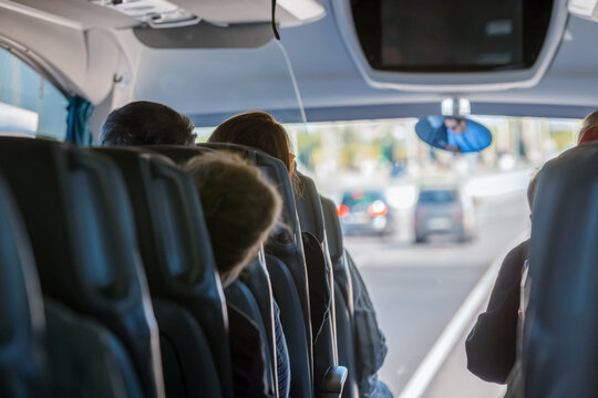 Interior view of a modern coach bus featuring comfortable passenger seats, tray tables, and large windows for a scenic road trip journey
