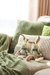 Cozy Sofa with Plush Easter Bunny Dolls and Textured Pillows in Sunlight