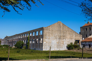 Abandoned industrial building with long concrete facade and empty windows in coastal area, Portugal, S&atilde;o Jacinto, 13 October 2025