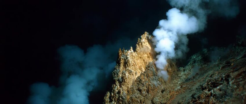 A geothermal vent creates a mesmerizing display of steam and minerals in the deep ocean.