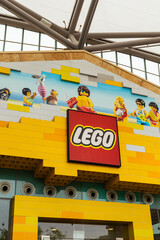 Obraz premium Singapore - January 7, 2026: People walk in front of a LEGO store in Singapore. The building features bright colors and playful designs. Families and children enjoy the fun atmosphere