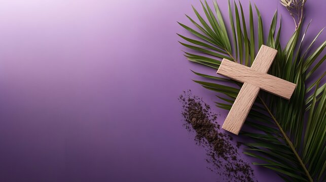A Christian cross made of wood lies on a purple background with palm leaves and ash for Ash Wednesday.