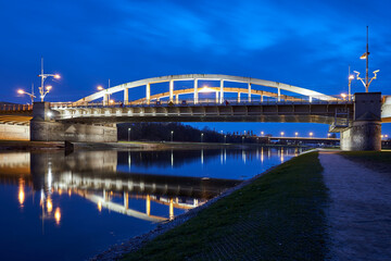 The steel structure of the road bridge over the Warta River during the night in the city of Poznan