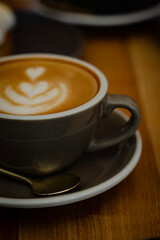 Obraz premium Hot cappuccino on a wooden table in a cozy café atmosphere