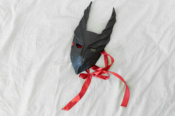 carnival mask festive ribbon hand craft product on a sheet pastel textile background pattern wallpaper advertising space