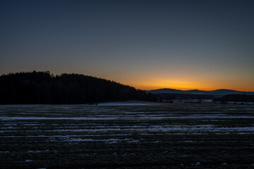 Silhouette of mountains and forests with sunrise colors in winter morning