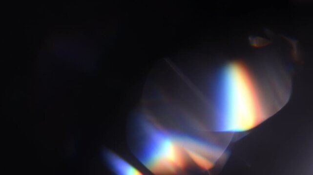 Cinematic lens flare light on black background, abstract optical glow and colorful bokeh overlay, perfect for transitions, titles, visual effects and creative video projects.