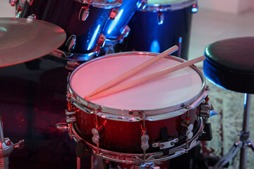 Obraz premium Modern drum kit with drumsticks in studio, closeup. Musical instrument