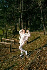 Fototapeta premium Caucasian young adult female enjoying autumn day in park