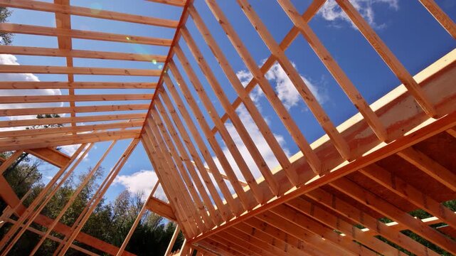 Workers build wooden beams joists roofing frame for house