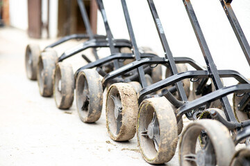 A row of dirty lawn mowers are lined up