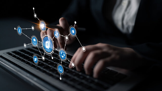 A person types on a laptop surrounded by digital connectivity icons, representing modern business communication and innovative strategies in a professional setting. Tessel - Powered by Adobe