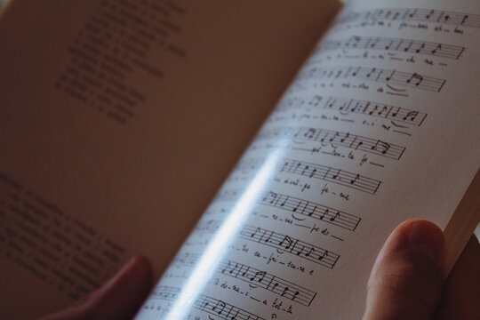 Close-up di brano musicale in lingua locale con testo a lato.