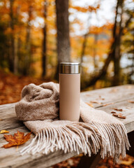 Cozy autumn scene with thermos and scarf