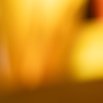 Abstract golden yellow bokeh background with soft orange light leak and warm glowing blur