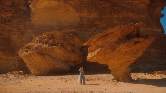 Woman travels in Saudi Arabia, standing by the sand rocks in AlUla. Tourist destination in Al Ula desert