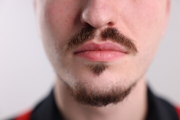 Obraz premium Man with mustache on light background, closeup