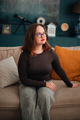 Obraz premium Psychologist sitting on a couch with a relaxed posture in a modern room during daytime