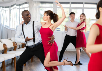 Couple of adult man and adult woman dancing tango in studio