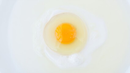 Raw egg yolk and white in a bowl, fresh ingredient for cooking, baking, breakfast, or healthy food preparation