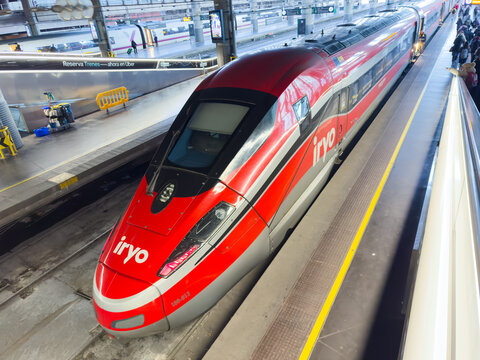 Iryo high velocity train is stopping at the platform inside madrid atocha railway station, providing modern public transportation and travel connections
