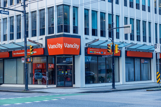 Vancity credit union branch storefront with red signage on ground floor of white downtown Vancouver building