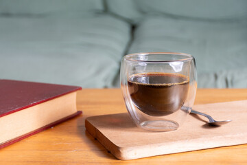 A moment of relaxation with a cup of coffee and a book in the living room armchair.