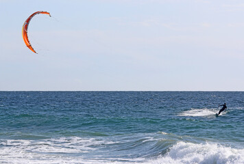 kitesurfer riding his board on the sea	