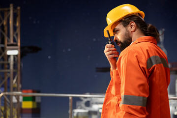 Offshore platform technician providing operational updates over walkie talkie network. Drilling rig...