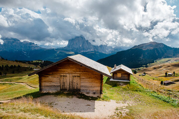 Seceda mountain huts in the Dolomites, Italy with dramatic clouds overhead