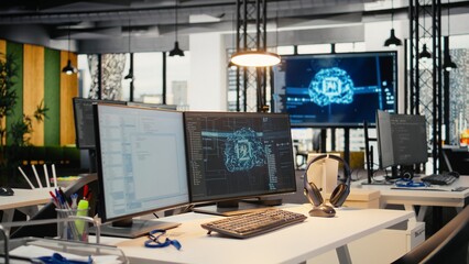 Computer monitors in empty startup workspace with cloud computing AI resources. PC screens in modern office constructing neural network algorithms using programming languages