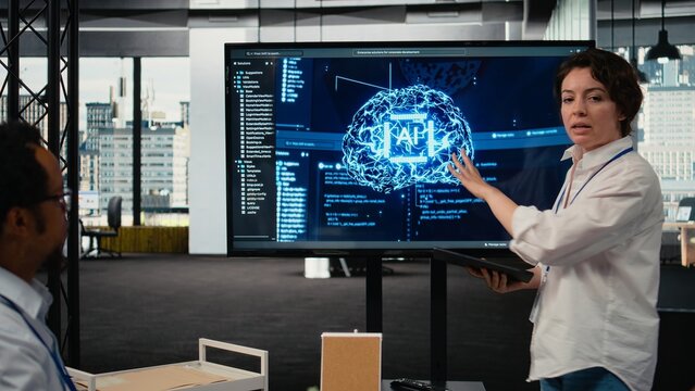 Investors gathered in tech startup boardroom to do deep dive into artificial intelligence. Programmer showcasing latest innovations in AI sector at corporate event in front of businesspeople, camera A