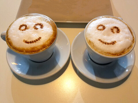 Two Cappuccino Coffee Cups with Froth Art