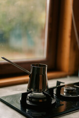 Obraz premium Coffee pot on gas stovetop by window