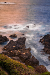 Long Exposure of Dramatic Sunset Reflecting in the Waves Crashing on Vancouver Island Rocky Coastline at Golden Hour