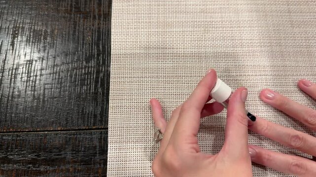 Oval diamond solitaire engagement ring on hand with neutral nails