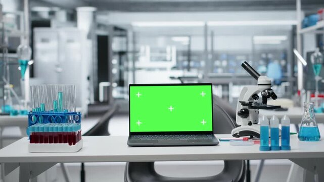 Green screen laptop and scientific gear in research facility used for complex experiments. Empty high tech laboratory workstation with genetic research lab equipment and chroma key laptop