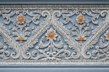 Obraz premium Ornate architectural molding displays intricate stucco floral patterns against a muted blue background