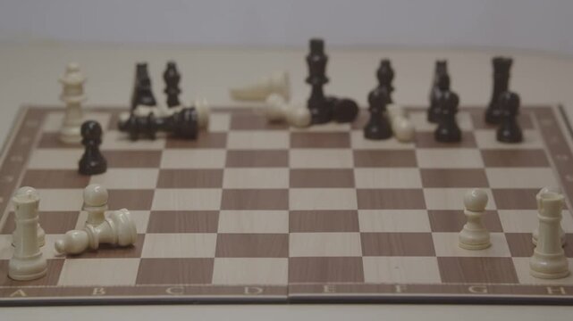 A cinematic shot of a chess game for White, showing the scattering and knocking down of chess pieces on the board after checkmate. The concept of bold strategy and surprise in a chess game.