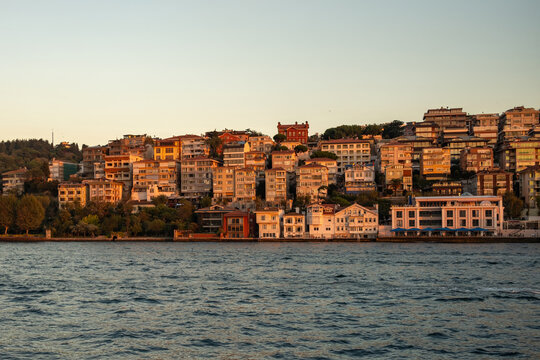 Golden hour over Uskudar on Asian side of Istanbul, Turkey, seen from the Bosphorus, with hillside homes in warm evening light against clear sky