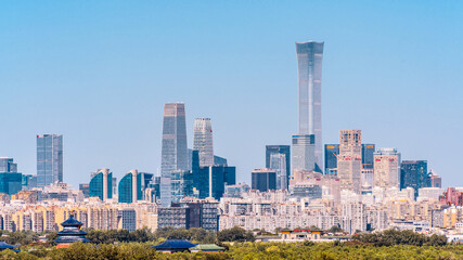 Obraz premium A panoramic view of the Temple of Heaven and skyline in Beijing, China, comparing ancient and modern times.