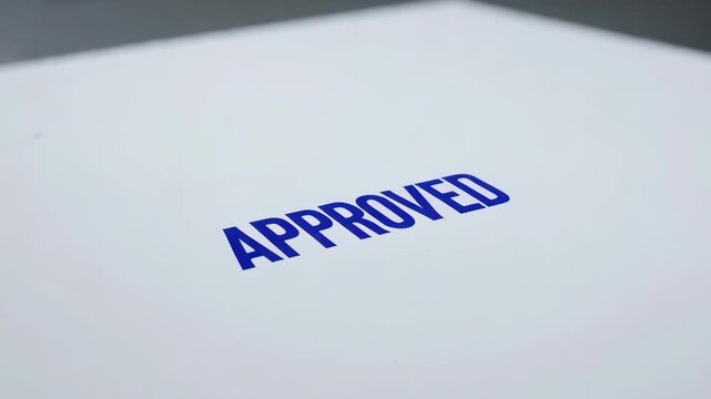 Document with blue approved stamp on white background  