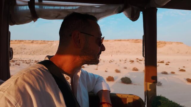 Tourist man enjoy desert safari in Zekreet, Qatar at the sunset time