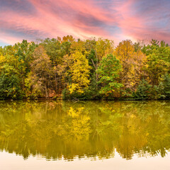 Autumn forest reflected in calm Black Creek in Port Dover at sunset in Ontario, Canada