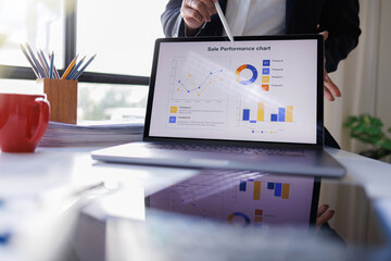 Business woman analyzing summary report data on laptop in modern office report graphics meeting at office
