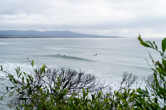 Surfers in the distance beach and mountains view