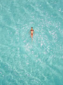 Mujer joven latina y hermosa, nadando en el hermoso mar azul del Caribe. Vista a&eacute;rea de una mujer nadando en un lugar paradis&iacute;aco